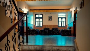 A staircase with ornate railings leading to a room with a patterned floor and a view of the outside through large windows. - Rufina Norling Zimkhang (Chungthang)