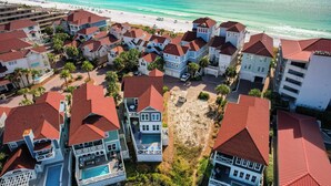A coastal residential area with houses featuring red roofs, a beach, and a clear view of the ocean. - Song By the Sea - Steps to the Beach, Gated, Sleeps 14! (Miramar Beach)