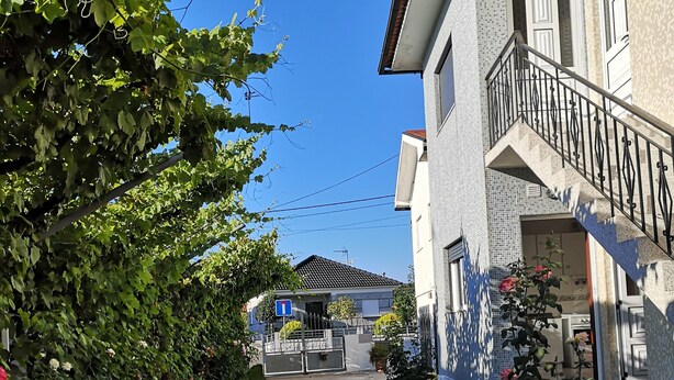 A stone pathway leading to a building with a tiled exterior and a metal staircase.