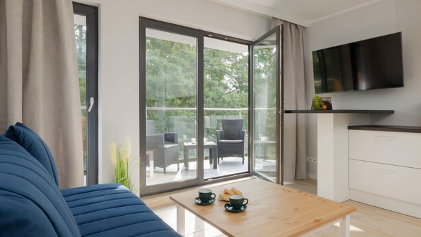 Un salon moderne avec un canapé, une table basse et un téléviseur fixé au mur.
