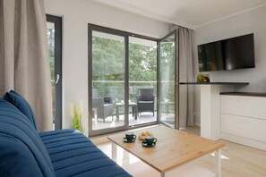 Un salon moderne avec un canapé, une table basse et un téléviseur fixé au mur.