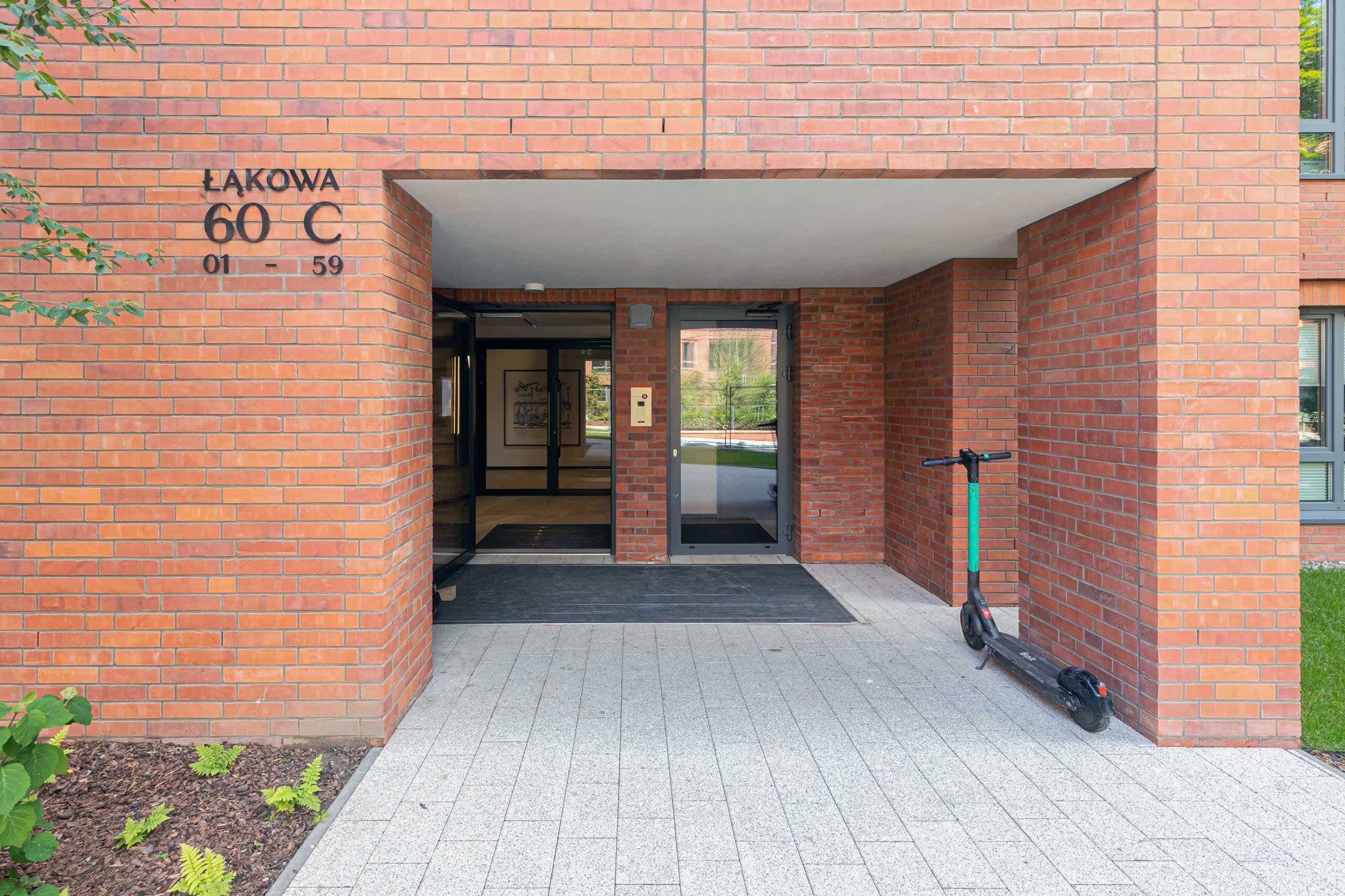 Entrada de un edificio de ladrillo con un letrero que dice "LAKOWA 60 C 01-59".