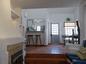 Cozy living area with a fireplace, dining space, and a staircase leading to an upper level.