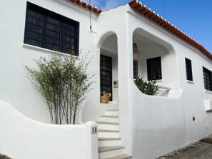 Stunning building with a curved facade, featuring a red-tiled roof and black-framed windows.