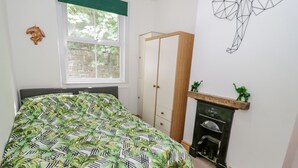 Une chambre à coucher comprenant un lit, une armoire, une cheminée et un élément décoratif mural.