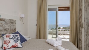 A hotel room with a bed, a view of the sea, and a balcony with outdoor furniture. - Mercury Beach Hotel (Sant'Antioco)