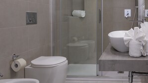 A modern bathroom with a glass-enclosed shower, a large white sink, and a toilet. - Mercury Beach Hotel (Sant'Antioco)