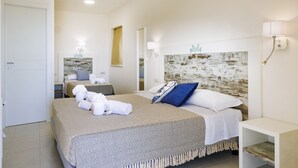 A hotel room with two beds, a bedside table, a nightstand, and a headboard with a rustic design. - Mercury Beach Hotel (Sant'Antioco)
