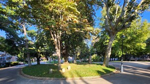 A park with a circular grassy area, trees, and a paved road. - Logement Entier à Proximité des Plages et Commerces (Sète)