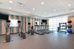 A gym with treadmills, elliptical machines, and a weight rack with various exercise balls. - Home2 Suites by Hilton Vero Beach I-95 (Vero Beach)