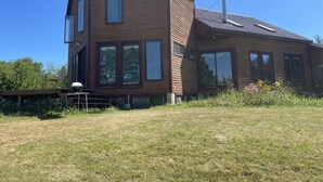 A modern two-story house with large windows and a sloped roof. - Spacious home w/riverview, minutes from state parks and ocean beaches, sleeps 11 (East Machias)