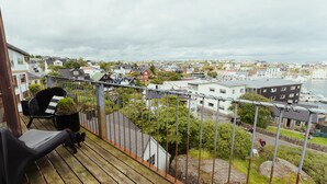 A balcony with a view of a town, including houses, a marina, and a body of water. - Penthouse - 4BR - Downtown - Harbour (Tórshavn)