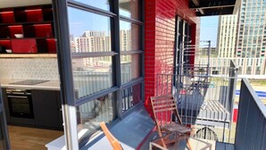 Un appartement moderne doté d’un balcon, de grandes fenêtres et offrant une vue sur la ville.
