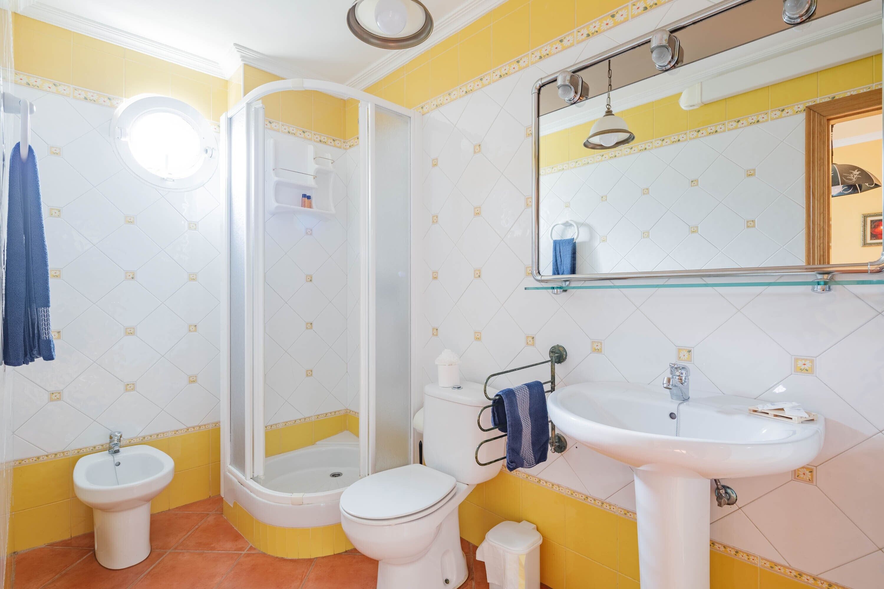 Une salle de bain équipée d’une douche, de toilettes, d’un bidet et d’un lavabo.