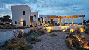 Una villa moderna con un espacio de estar cubierto al aire libre, un jardín cuidado y vistas al mar.