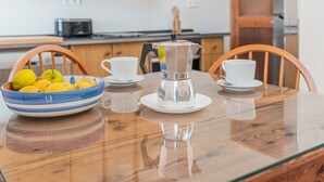 Eine Küche mit einem Holztisch, einer Kaffeemaschine, einer Zitronenschale und einem Toaster.