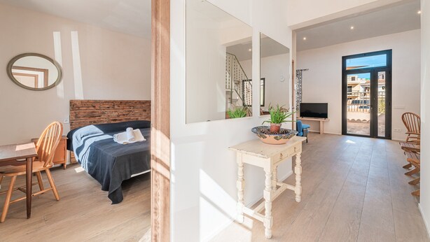 Ein modernes Hotelzimmer mit Bett, Schreibtisch, Stuhl und einem großen Spiegel.