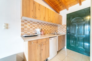 A kitchen with wooden cabinets, a tiled backsplash, a coffee maker, and a dishwasher. - Studio Apartment 'Arianna Deluxe Studio 21' with Sea View, Shared Pool & Wi-Fi (Corfu)