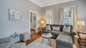 A living room with a grey sofa, two side tables with lamps, a coffee table, and a patterned rug.