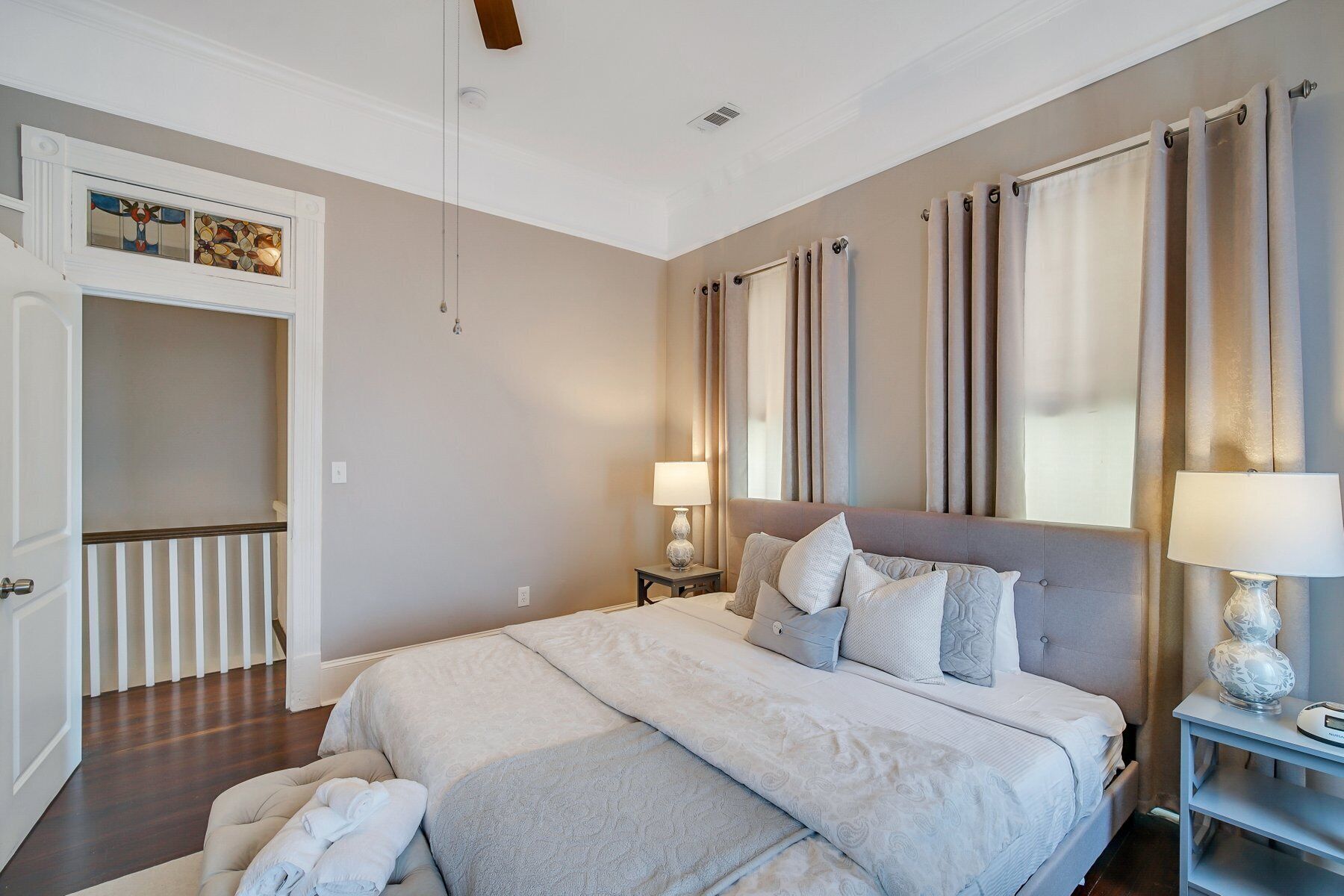 A bedroom with a large bed, a nightstand, a lamp, and a wardrobe.