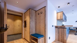 Een moderne keuken met houten kasten en een blauwe, beklede bank.