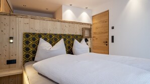 Een slaapkamer met een groot bed, houten hoofdbord en een houten deur.