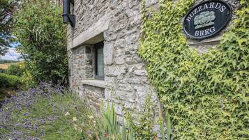 A stone building with a sign reading 'BUZZARDS BREG' and a window.