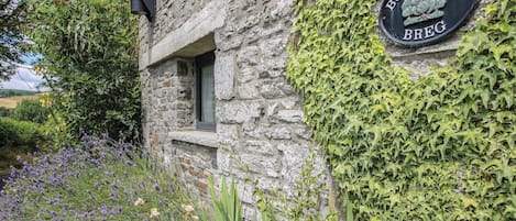 Un edificio de piedra con un cartel que dice 'BUZZARDS BREG' y una ventana.
