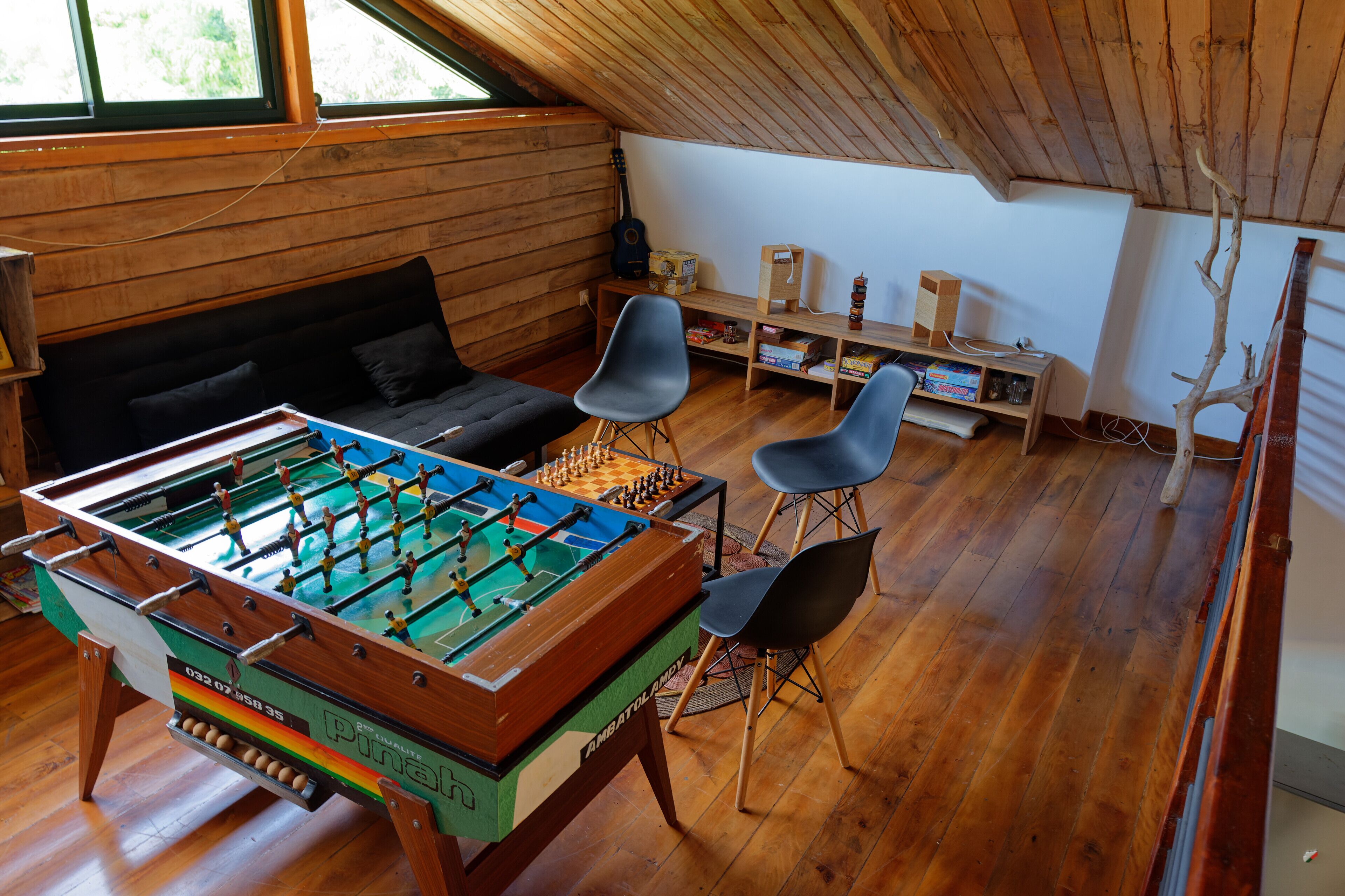 Una habitación acogedora con mesa de fútbol, un sofá y dos sillones.