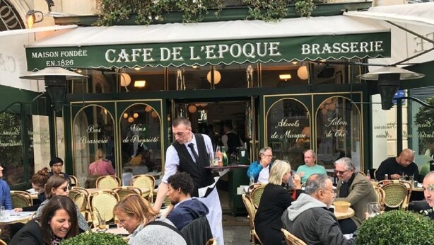 An outdoor cafe with tables and chairs, a waiter, and patrons. - THE FRENCH CAPITAL ABODE;LOUVRE , TUILERIES, PLACE VENDOME (Paris)