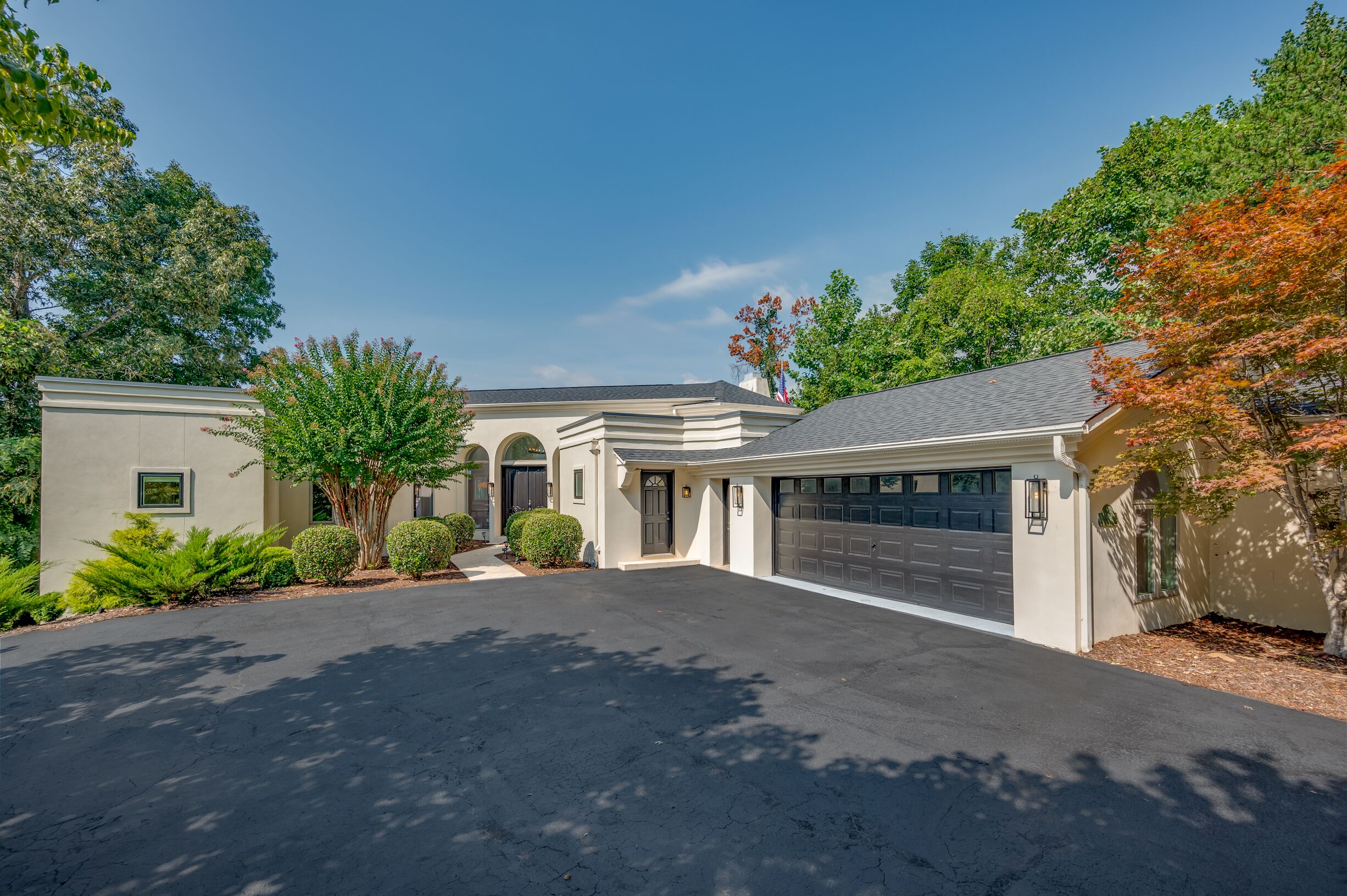 A two-story house with a garage, a driveway, and a well-maintained lawn.
