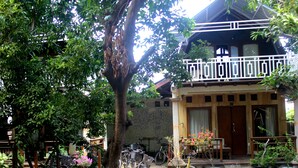 A courtyard with bicycles, a wooden bench, and potted plants. - GILI BEACH WIND (Gili Trawangan)