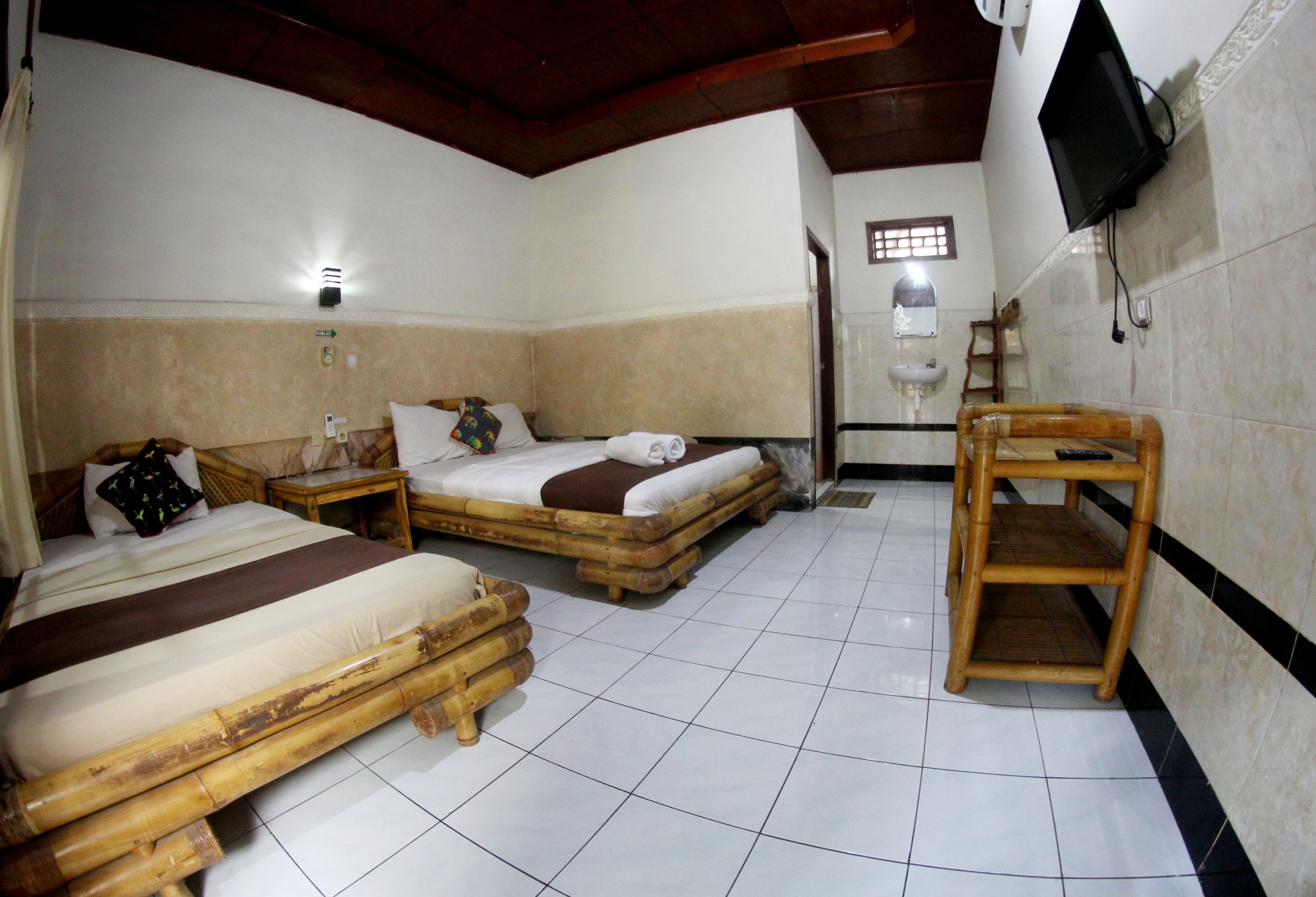 A room with two beds, a television, a wooden chair, and a small table.