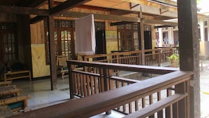 A wooden balcony with railings, a bench, and a hanging white cloth. - GILI BEACH WIND (Gili Trawangan)