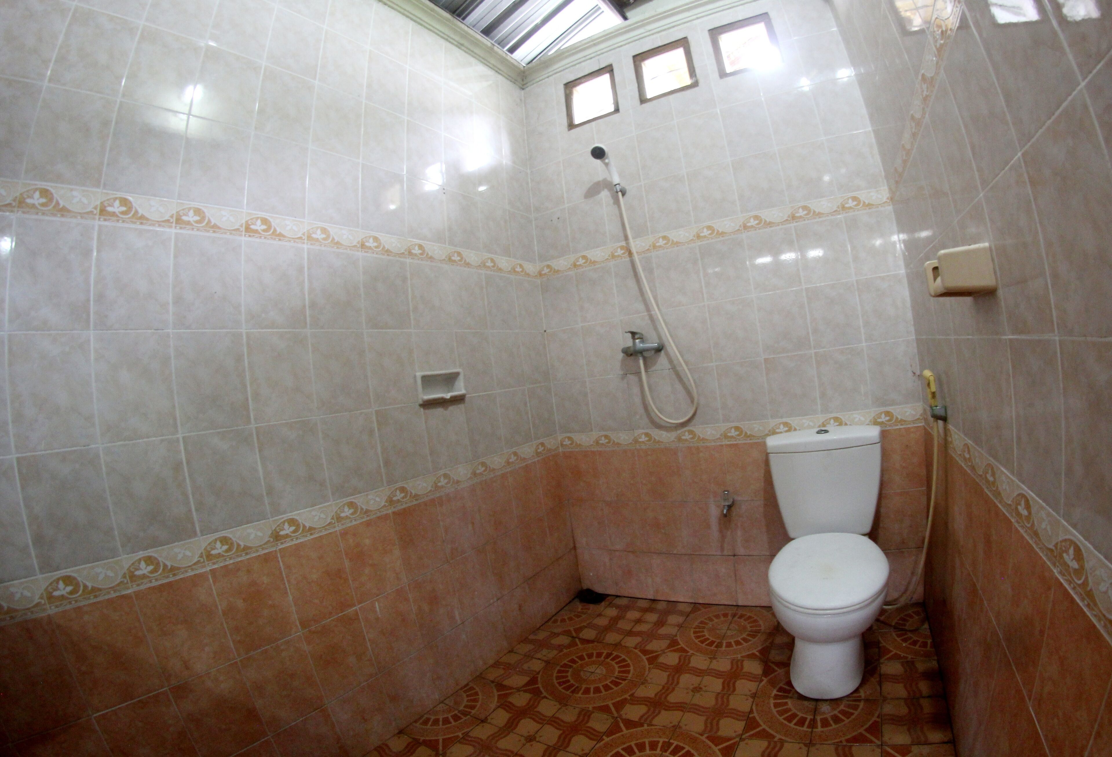 Een kleine badkamer met een toilet, een douche en een wastafel.