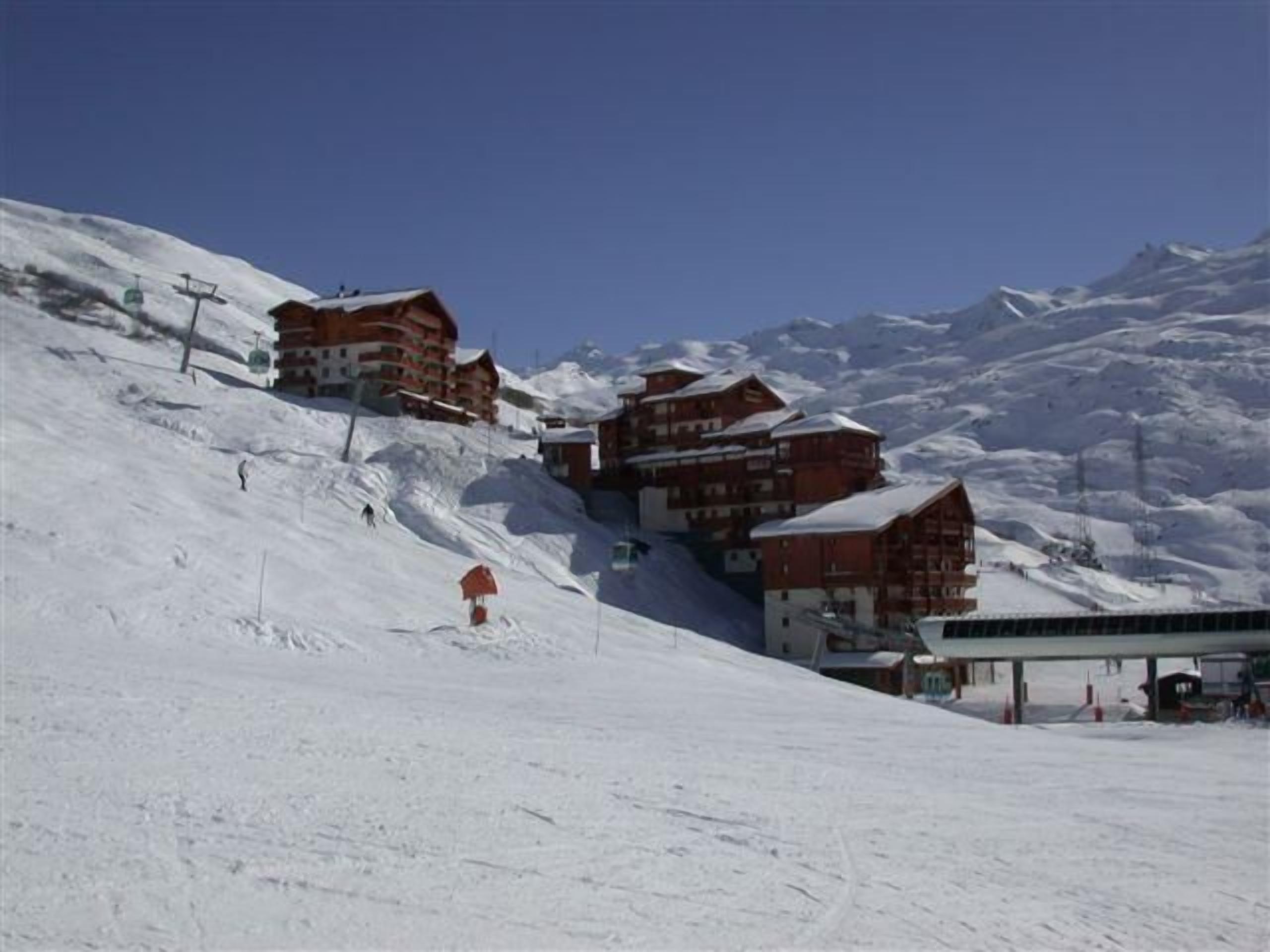 Una muntanya plena de neu amb edificis de fusta i un telefèric.