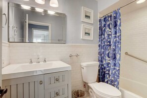 Bathtub, hair dryer, towels, shampoo