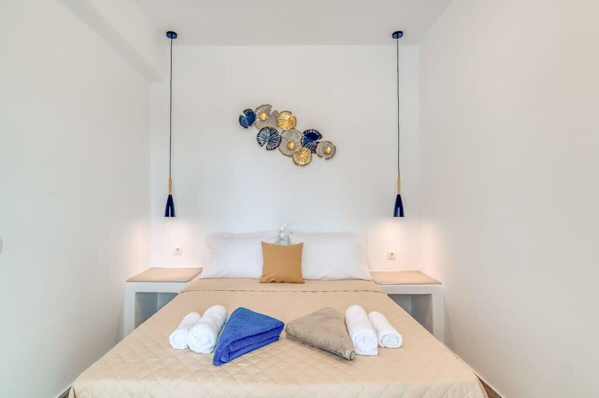 Ein Hotelzimmer mit einem Bett, zwei Nachttischen, einer Wandleuchte und einem dekorativen Wandbild.