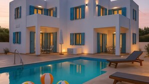 A modern two-story house with a swimming pool, outdoor seating, and blue shutters.
