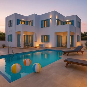 A modern two-story house with a swimming pool, outdoor seating, and blue shutters. - Paros Dream Haven - Venus's Seaside Bliss (Aliki)