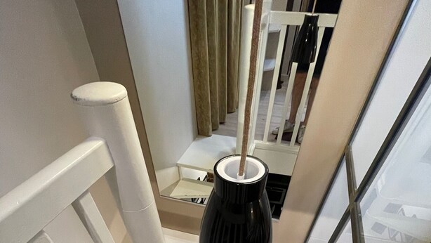 A modern staircase with white railings and a black vase on the landing. - Quartier Voltaire - Rue Pache (Paris)