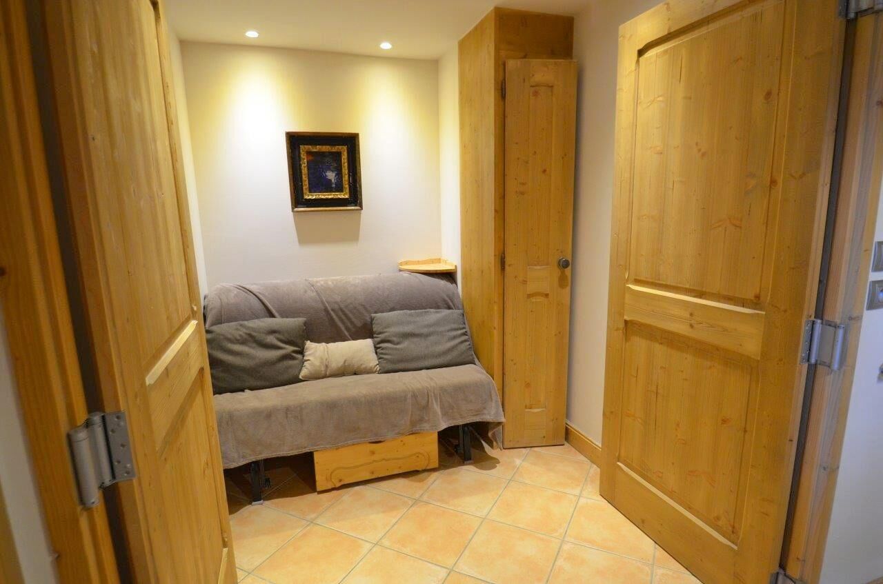 A bedroom with a bed, a wooden door, and a framed picture on the wall.