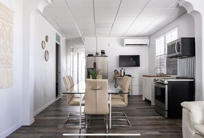 A modern kitchen with a dining area, featuring a flat-screen TV, stainless steel appliances, and a minimalist design. - 9 Bedrooms Large home San Juan Santurce (San Juan)