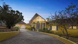 A yellow building with a symmetrical facade, large windows, and a central entrance. - Yancey Largo Villa Perfect Jamaica Ironshore Getaway w Private Pool and Onsite Staff Services by RedAwning (Montego Bay)