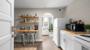 A modern kitchen with white cabinets, a wooden countertop, and a built-in microwave. - Broad Street Suites 1,2 & 3 |Sleeps 20 |Parking for 7 Vehicles |Downtown |Events |Horticultural Hall (Lake Geneva)