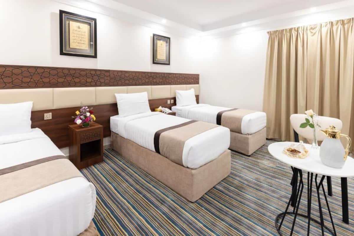Una habitación de hotel con dos camas, una mesita y una mesita de noche.