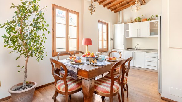 Un coin repas avec une table en bois, des chaises et une plante en pot.