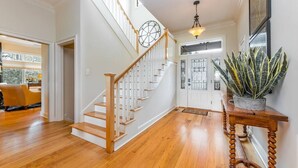 Una escalera de madera con barandilla blanca que lleva a una plataforma.