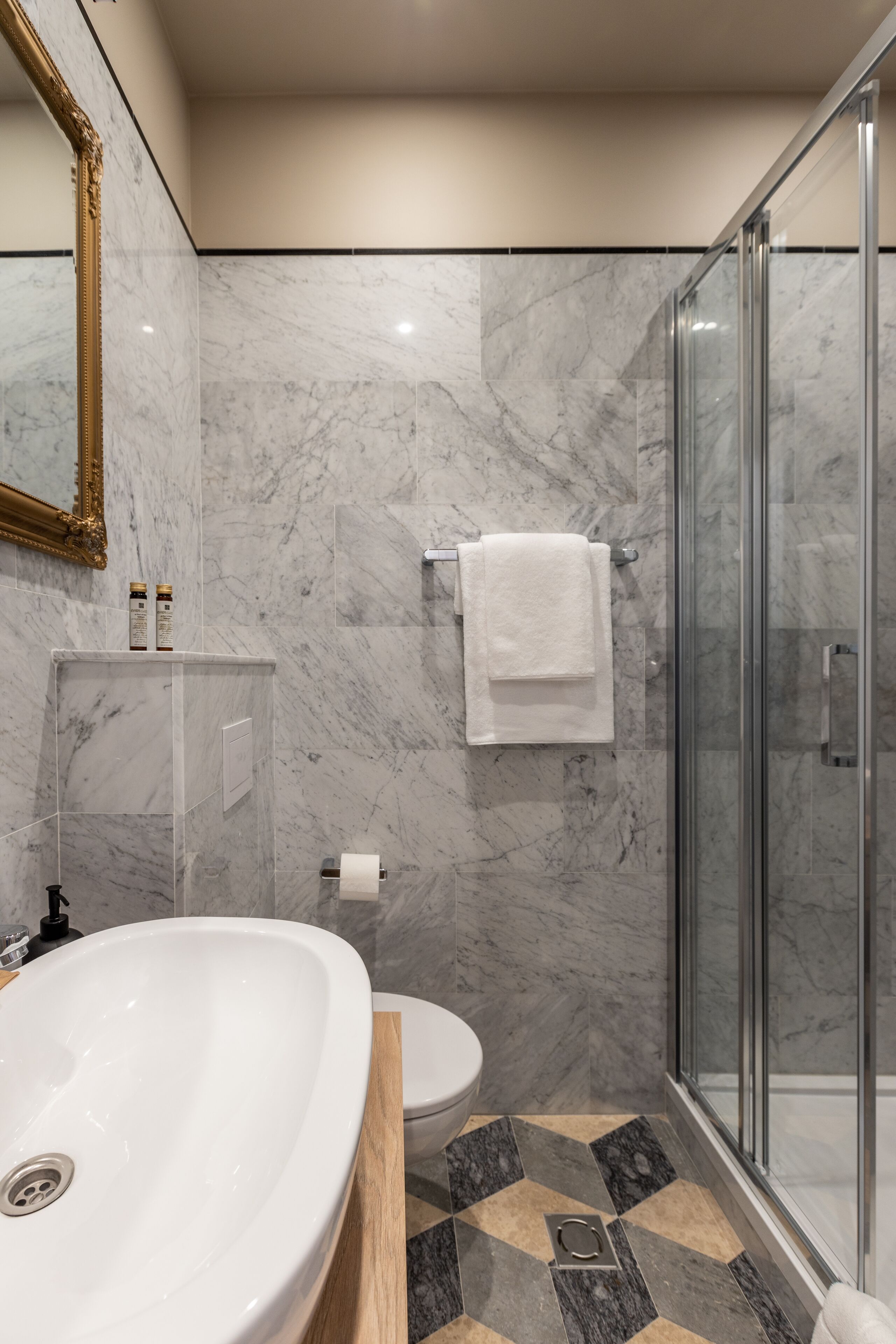 Ein modernes Badezimmer mit Marmorwaschbecken, Toilette und Dusche.