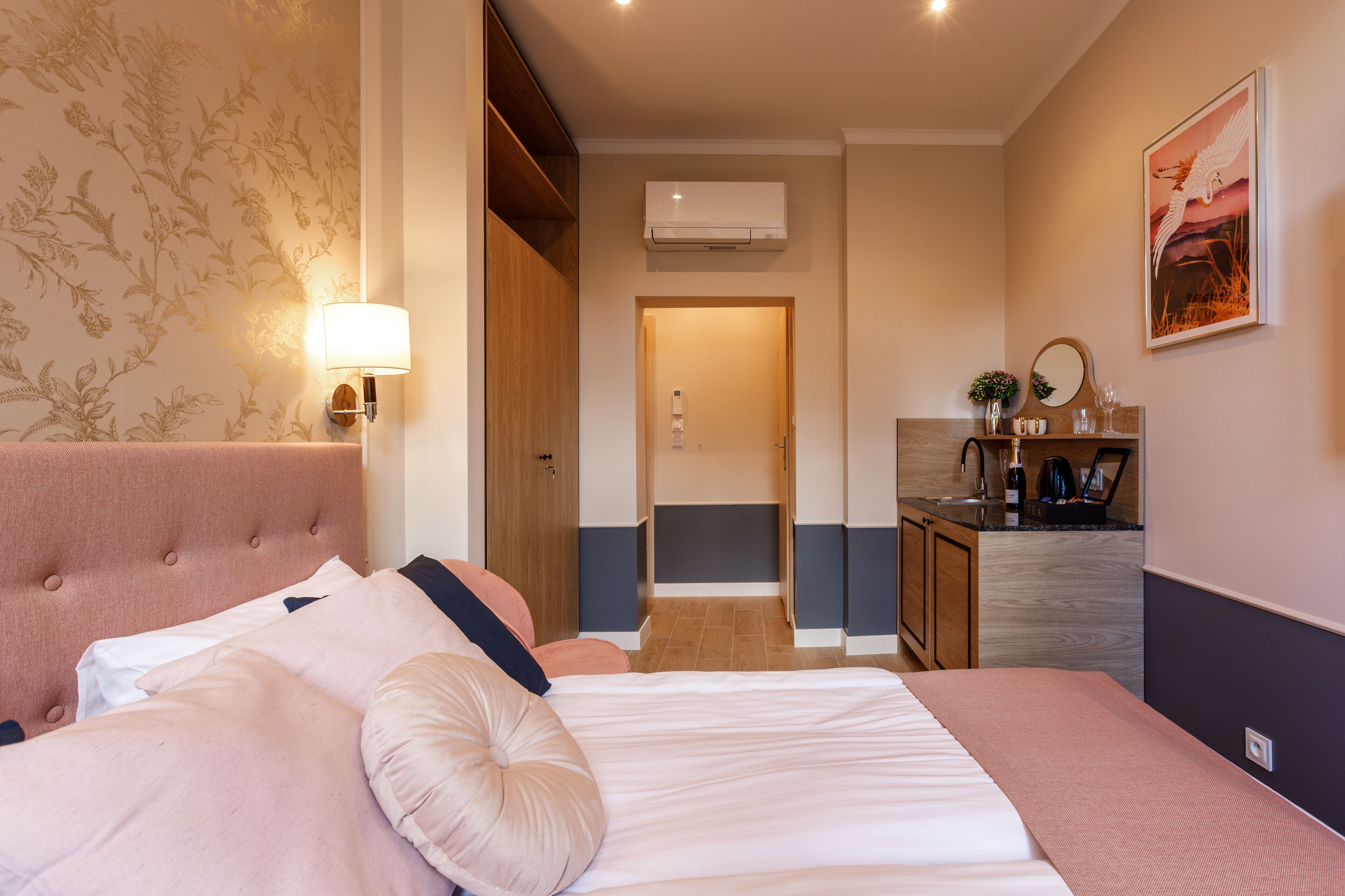 Ein Hotelzimmer mit Bett, Nachttisch, Lampe und Blick ins Bad.